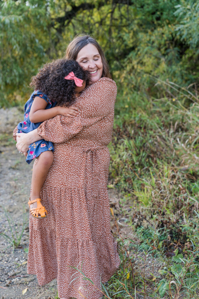 Mom and daughter, daughter is giving the sweetest hug and mom is smiling so happy to have this moment captured. 