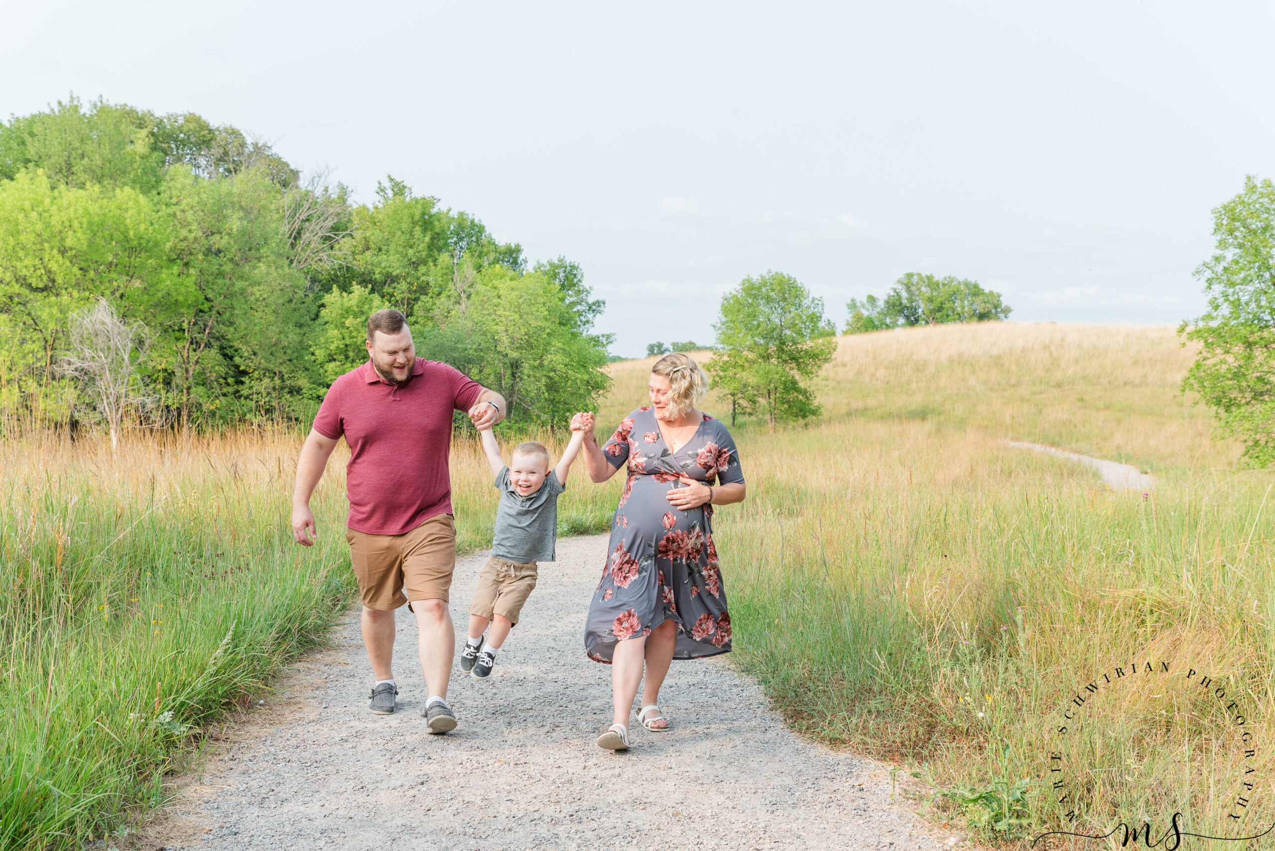 Dad wearing red shirt, mom wearing a dress and little boy between them