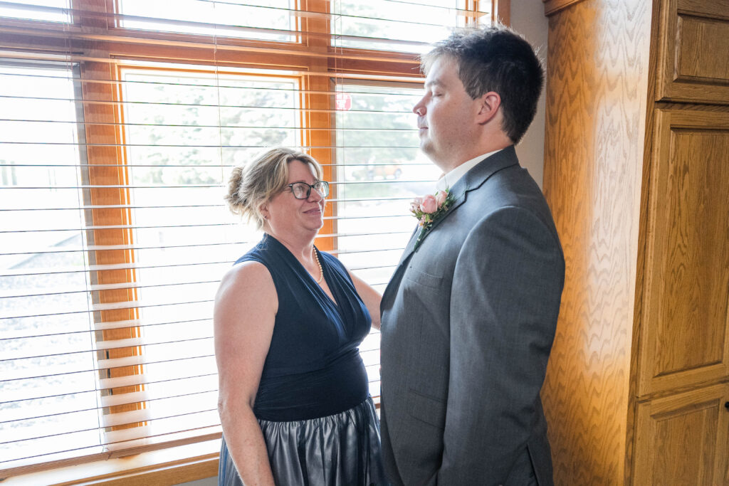 Mom and Son standing together before his wedding. 