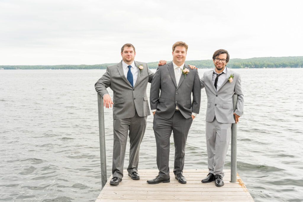 Groom and groomsmen standing on a dock at Fair Hills Resort in Detroit Lakes, MN 