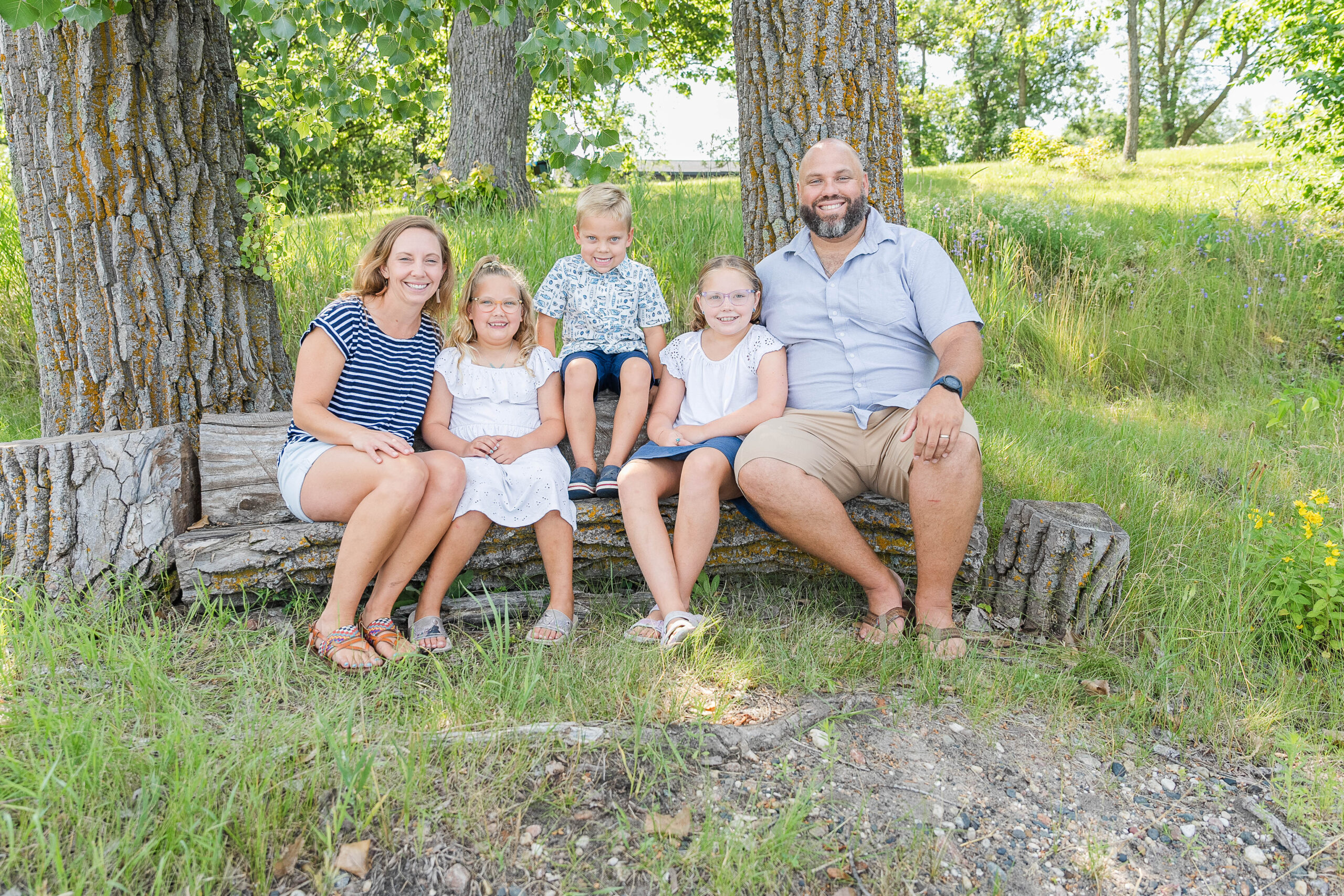 Family of 5 sitting on a wooden bench