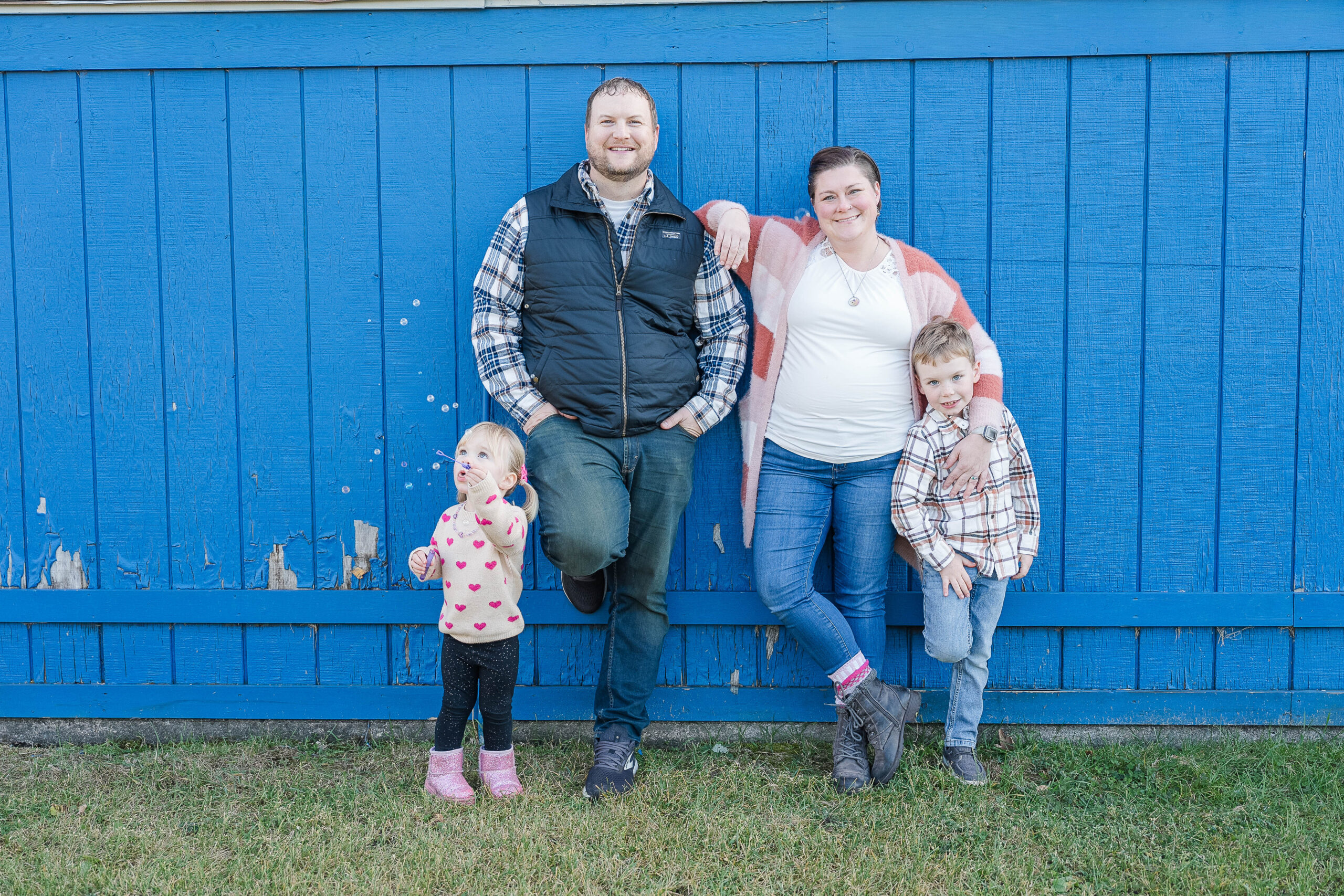 Family of Four standing against a blue background